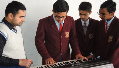 Students practicing keyboard and instrumental music in the school music room
